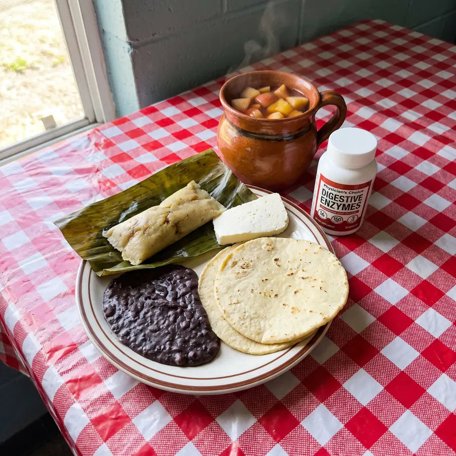 Plato chapín con frijol, tamal, queso fresco, tortillas y ponche junto al frasco